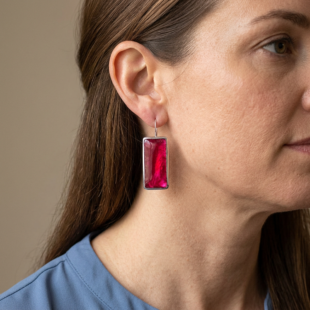 Model wearing magenta rectangular earrings